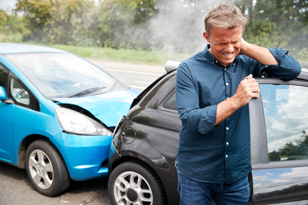 Man in car crash suffering whiplash injury