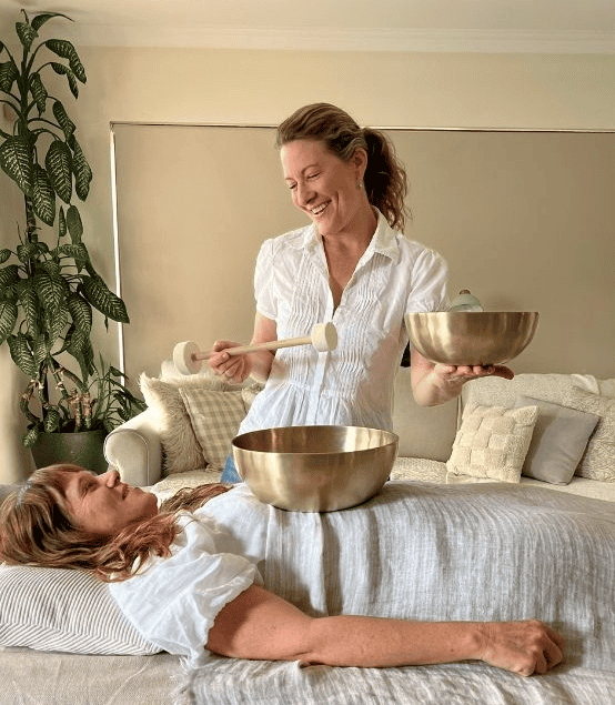 image of woman providing sound bath massage healing for patient
